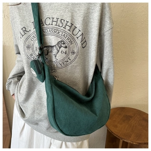Detail of dark green corduroy hobo bag with matching round coin purse charm accessory