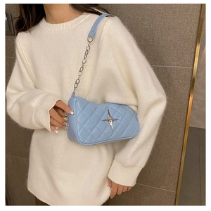 Detail of light blue quilted PU leather bag with silver star buckle and chain strap