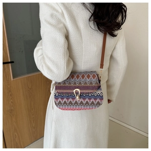 Ethnic woven crossbody bag with colorful geometric patterns and gold horseshoe clasp