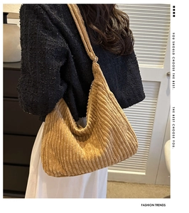Detailed view of the yellow corduroy hobo tote bag texture on a model's shoulder