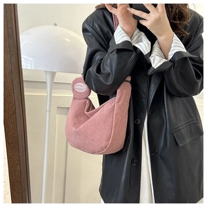 Detailed close-up of pink corduroy crescent shoulder bag with a mini round coin purse