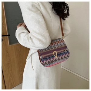 Close-up of ethnic woven crossbody bag with colorful patterns and metallic buckle detail