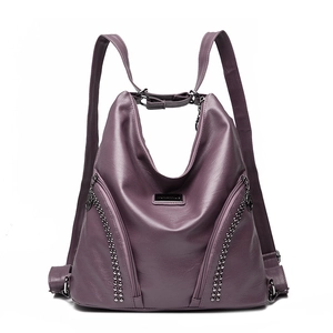 Purple faux leather backpack with silver rivets and zippers on a clean white background