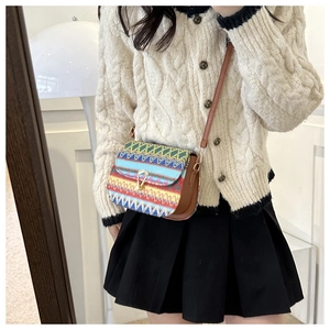 Detail of bohemian style ethnic crossbody bag with colorful patterns and leather trim