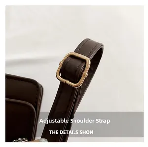 Detail of dark brown leather strap with adjustable gold rectangular buckle and fine stitching