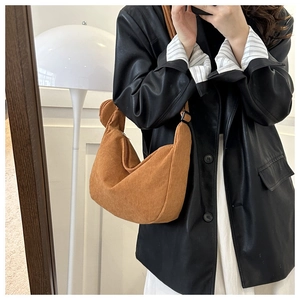 Brown corduroy half-moon shoulder bag with zipper closure shown on a model