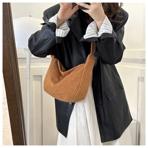 Detailed texture of brown corduroy crescent bag with stylish vertical striped fabric