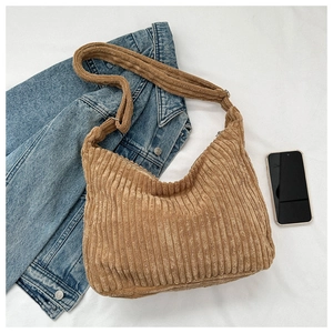 Detail of soft corduroy tote bag featuring adjustable strap and metallic hardware finish