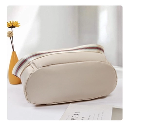 Détail du sac à bandoulière en nylon beige avec large sangle rayée rouge et verte