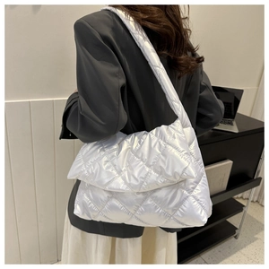 Gros plan d'un sac bandoulière matelassé blanc perle avec motif à losanges porté
