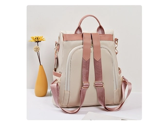 Vue arrière du sac à dos en nylon beige avec garniture en cuir rose et poche zippée antivol