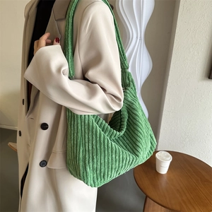 Detail of green corduroy hobo bag showing soft ribbed texture and large capacity fit