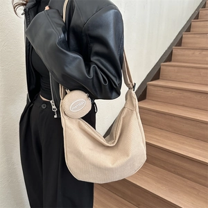 Beige corduroy crescent crossbody bag with small round coin purse shown on model