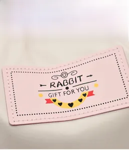 Détail du sac à dos en toile crème avec étiquette de lapin rose et broderie élégante
