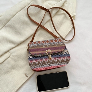 Ethnic bohemian woven crossbody bag with colorful zig-zag patterns and golden buckle