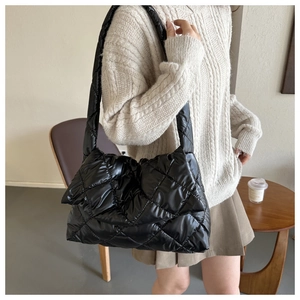 Détail du sac à bandoulière matelassé noir montrant sa grande capacité et sa texture douce