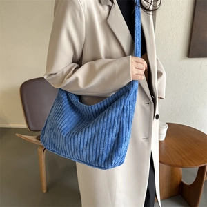 Detail shot of the soft navy blue corduroy fabric and wide strap on the tote bag