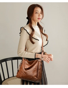 Detail of vintage brown PU leather crossbody bag featuring V-shaped quilting and fringe