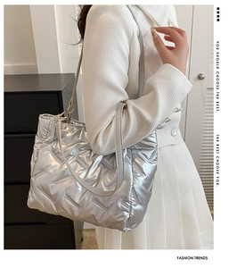 Sac fourre-tout matelassé argenté porté à l'épaule avec une tenue blanche chic