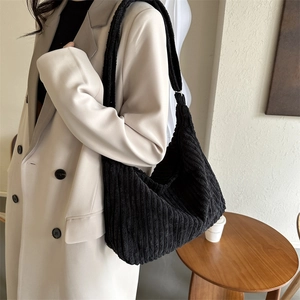 Detail of black corduroy tote bag showing soft ribbed texture on shoulder bag