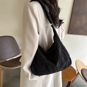 Detail of soft black corduroy tote bag showing vertical stripe texture and wide strap