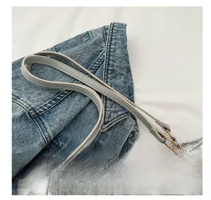 Détail des anses d'un sac cabas argenté matelassé avec anneaux métalliques dorés