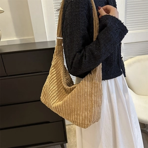 Side view of soft khaki corduroy tote bag worn over the shoulder showing large capacity
