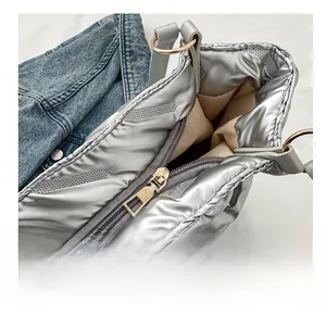 Détail du zip en métal fluide et du tissu matelassé argenté sur ce sac cabas chic