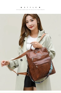 Close-up of vintage brown leather backpack with multiple zippers and bohemian strap