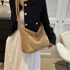 Detailed texture of the soft corduroy material and wide shoulder strap on the khaki tote bag