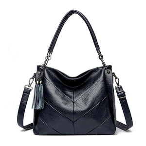 Detail of V-quilted texture and leather tassel on this minimalist crossbody tote bag