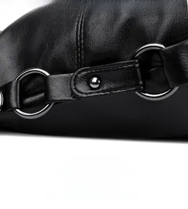 Macro detail of litchi grain leather bag showing metal ring and rivet strap craft