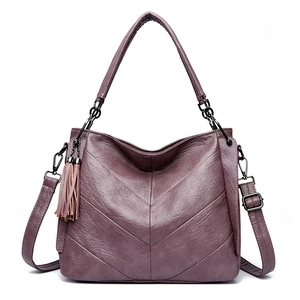 Close-up of purple litchi texture handbag with V-shaped stitching and tassel detail