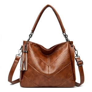 Large dark brown leather tote bag with V-shaped pleats and white tassel charm
