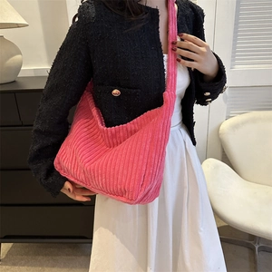 Detail of bright pink corduroy tote bag showing soft ribbed texture and wide strap