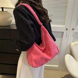 Detail of rose pink corduroy hobo bag showing soft ribbed texture and silver zipper