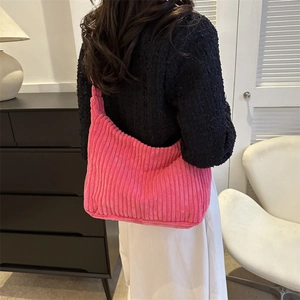 Detail of hot pink corduroy hobo bag showing soft ribbed texture and crescent shape