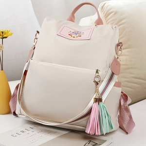 Sac à dos chic en nylon beige avec sangle rayée et pompons décoratifs pastel