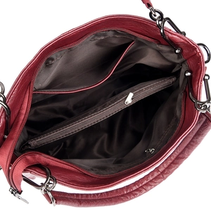 Detail view of burgundy leather handbag interior with multiple compartments and zippers