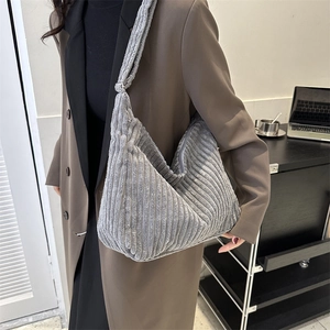Detail of grey corduroy tote bag with vertical texture and adjustable shoulder strap