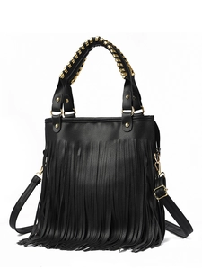 Detail of black pebbled leather handbag featuring long tassels and gold chain handle