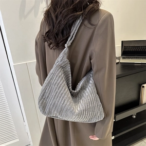 Detail of grey corduroy tote bag showing thick vertical texture and zipper closure