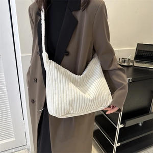 Detail of soft white corduroy texture on a large hobo tote bag with wide shoulder strap