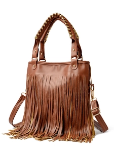 Close-up of brown faux leather handbag featuring long fringe tassels and gold hardware