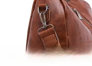 Detail view of anti-theft backpack with detachable dark gunmetal strap buckle and pebble leather