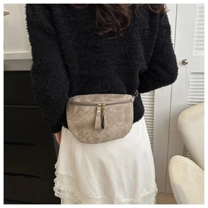 Détail d'un sac banane vintage en similicuir marron clair porté par un mannequin
