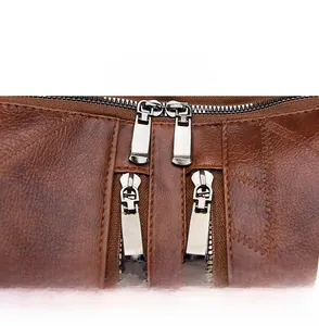Close-up of durable metal zippers on a brown lychee pattern leather anti-theft backpack