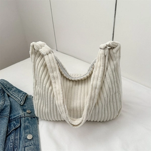 Detail of soft off-white corduroy tote bag showing ribbed texture and shoulder strap