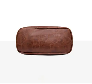Detail view of the rectangular bottom of the dark brown leather backpack with stitching