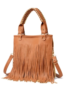 Detail of caramel brown tassel handbag in litchi grain faux leather with shoulder strap